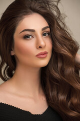 Naklejka premium Young woman with curly hair and makeup. Close-up portrait