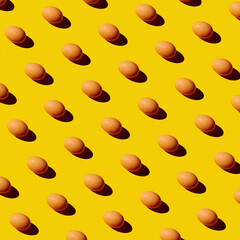 Chicken brown eggs pattern on yellow background. Festive Easter background from eggs