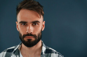 Close up portrait. Handsome man is in the studio against blue background