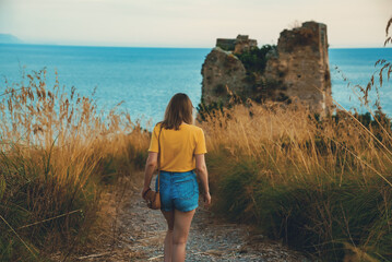 Tourist goes to Torre di Monte D'Oro in Scauri, Italy.