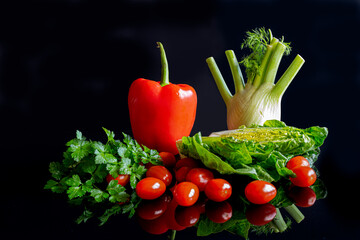  Salad vegetables on a black background, still life