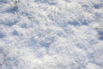 Beautiful winter background with snowy ground. Natural snow texture. Wind sculpted patterns on snow surface.