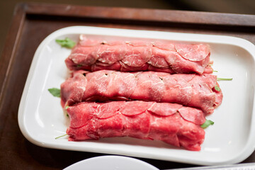Serving carpaccio. The chef burns the carpaccio with a burner. Carpaccio. Meat in the restaurant serving dishes