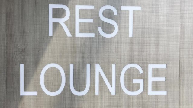 Close up shot of written rest lounge in the wall in the airport. Sign directing airport passengers where to go to rest and relax