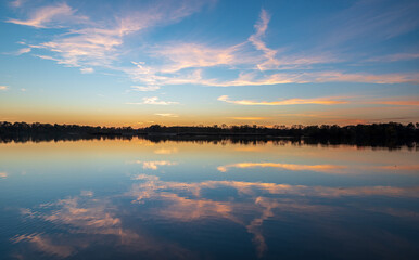 Obraz premium Pond with trees on the background and sky mirroring after sunsest