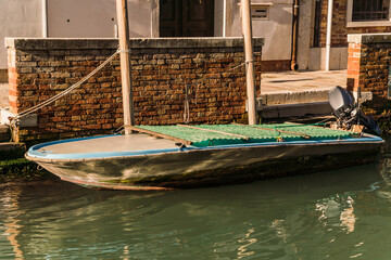 Fototapeta na wymiar Boats docked on canal in Venice, Italy
