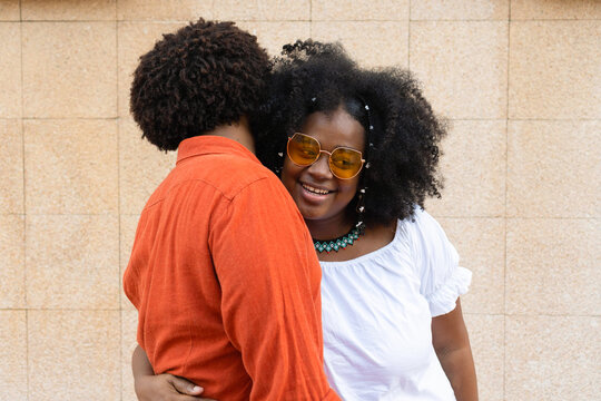 Elegant Ethnic Couple Embracing Against A Brick Wall.