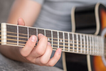 Boy learn to play the guitar. Closeup