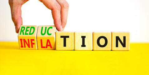 Inflation or reduction symbol. Concept word Inflation Reduction on wooden cubes. Businessman hand. Beautiful yellow table white background. Business inflation or reduction concept. Copy space.