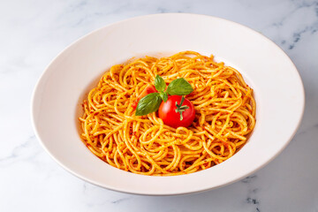 Tasty appetizing classic italian spaghetti pasta with tomato sauce, cheese parmesan and basil on plate and ingredients for cooking pasta on white marble table.