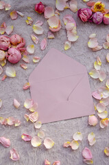 Craft pink envelope with small petals and rose buds on pink knitted background.Valentines Day background and Copy space for your text. Card design.