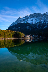 “Eibsee“ is an alpine Lake with crystal clear turquoise water underneath the highest summit of Germany the “Zugspitze“ (2.962 m) near Garmisch-Partenkirchen Bavaria. Popular winter sports destination.