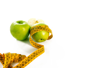 Green apples with measuring tape on white background, healthy diet