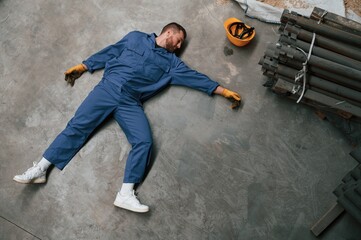 Top view of dead factory worker that lying on the ground. Conception of safety, bad accident