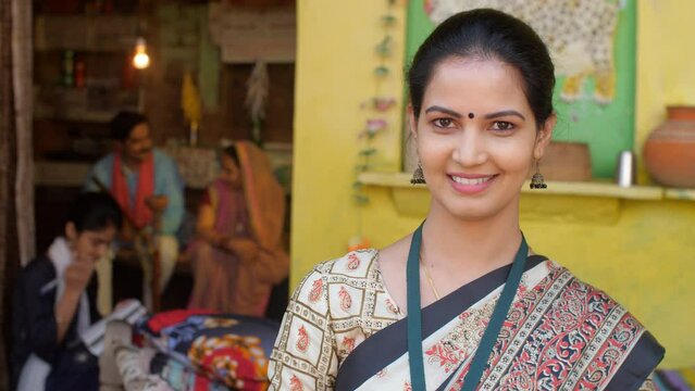 A government employee dressed in a saree posing for the camera - an educated woman in a village  government officer. A healthcare worked in an Indian village - sales agent  insurance agent in a vil...