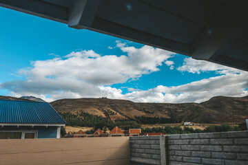 view from the window with blue sky clouds and mountains in the background