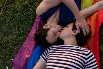 Happy young couple embraces. Two men enjoy in the park.