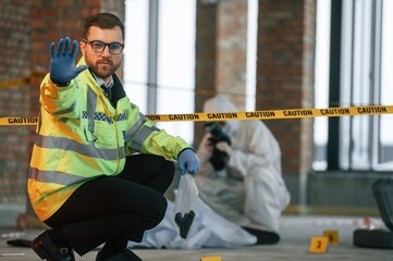 Fototapeta premium Dead body is on the ground. Detectives are collecting evidence in a crime scene