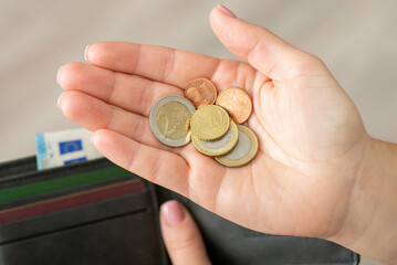 Close up shot of european coins on woman hand, wallet on the background. Business and banking in Europe, poverty and saving money concept