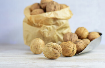 Close up. Wallnuts, full of properties, a source of protein, very healthy, in a metal shovel and behind in a kraft paper bag.