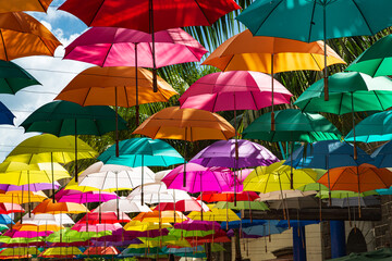 Colorful umbrellas spanning street at Caudan Waterfront shopping center, Port Louis, Mauritius - obrazy, fototapety, plakaty