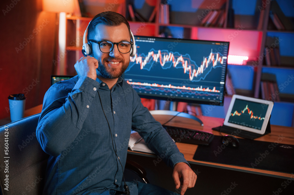 Aufkleber stock trader is working by pc indoors. conception of exchange and money