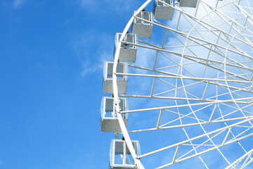 Fragment of a ferris wheel against the blue sky