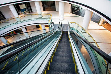 modern bright interior in a shopping center with an escalator. view from above