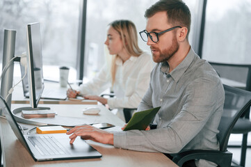 Obraz premium Using laptops. Successful team are working together in the office. Conception of business