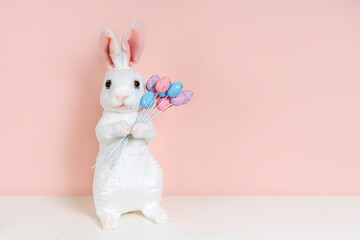 Easter Bunny with bouquet of colorful eggs on pink background. Home interior with easter decor.   Children's room in the Easter style. Holidays decorations.