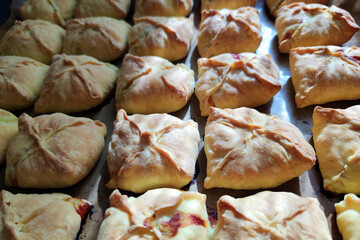 baked ruddy pies on a tray in the sunlight