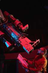 Astronomer with a big astronomical telescope in observatory doing science research of space and...