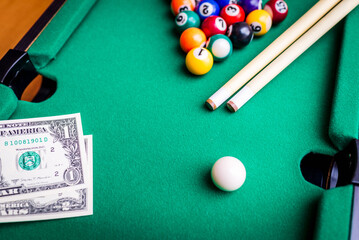 Gambling ardor game.Money and multicolored billiard balls with numbers.Dollar paper banknotes on...
