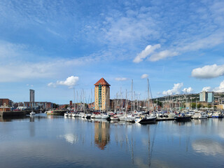 Apartment buildings surround the waterfront area on the River Tawe at the Swansea Marina. - obrazy, fototapety, plakaty