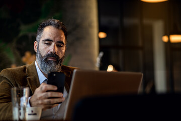 Businessman working in cafe using laptop.