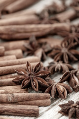 Background with cinnamon sticks, anise stars, coffee beans and nuts. Spicy trendy background. Close-up of various spices on wooden table top view