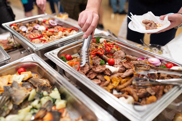 Fresh barbecue grill meat at buffet catering table. People serving themselves