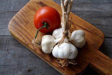 Garlic and tomatoes on wooden table