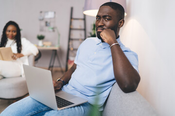 Black man working on laptop in living room
