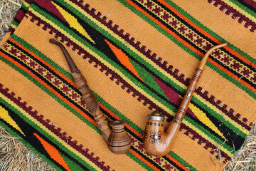 Wooden souvenir smoke pipes on the background of a woven hutsul carpet