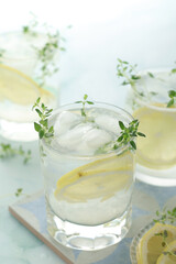 Glasses with lemon and thyme refreshing drink