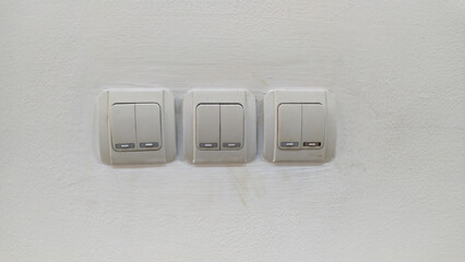 three pairs of light switch panels on a white wall