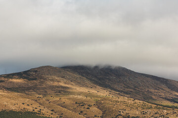 Clouds cover the top of the mountain on a cloudy autumn day.
