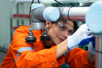 In an electronic parts facility, Female engineers In the plant, inspecting and testing robotic hands used in the production of electronic components.