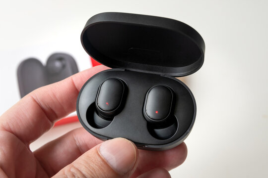 Man holding Redmi Airdots isolated, 11 Jan, 2023, Sao Paulo, Brazil.