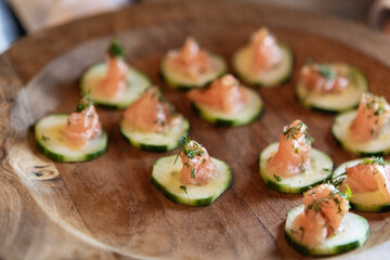 closeup of smoked salmon and herbs on cucumber slices