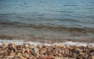 Fototapeta na wymiar Sea background with pebbles and splash of water foam