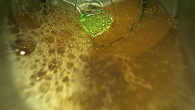 View inside from metal jar camera in soda can when water or liquid is pours out in super macro slow motion 1000fps. View from inside empty soda can in green background in extreme closeup green light