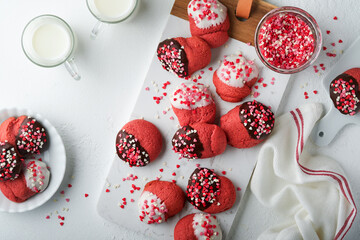 Valentines day cookies. Shortbread cookies with glaze white and dark chocolate and heart sprinkles on white marble stand on white background. Mothers day. Womans day. Sweet holidays baking. Top view.