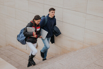 Cheerful students climbing up stairs together
